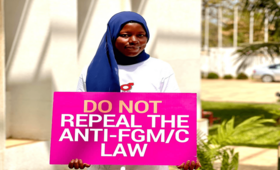 Anti-FGM activist holding a placard calling for the retention of the law banning FGM